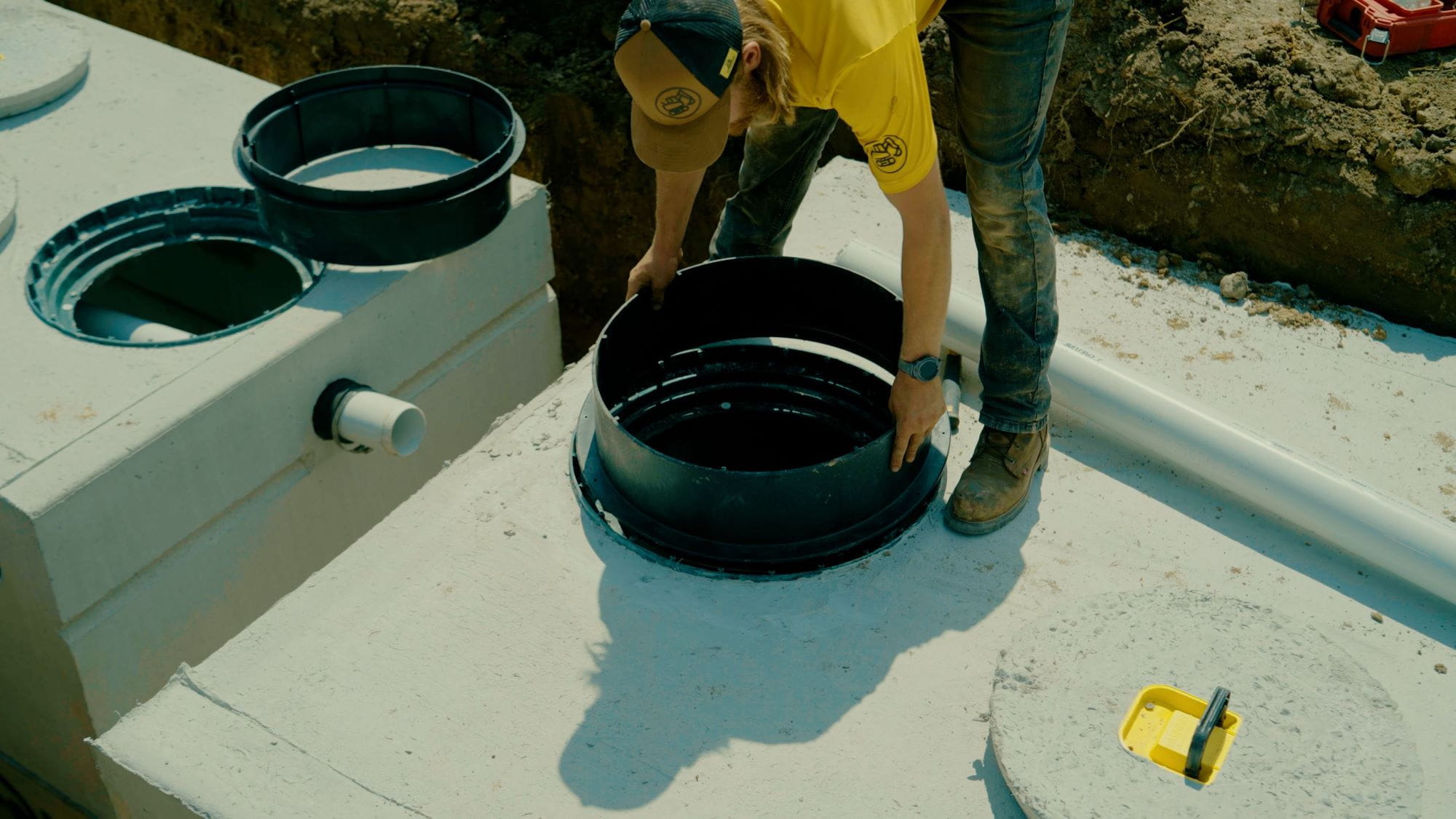 Workers install septic system equipment.