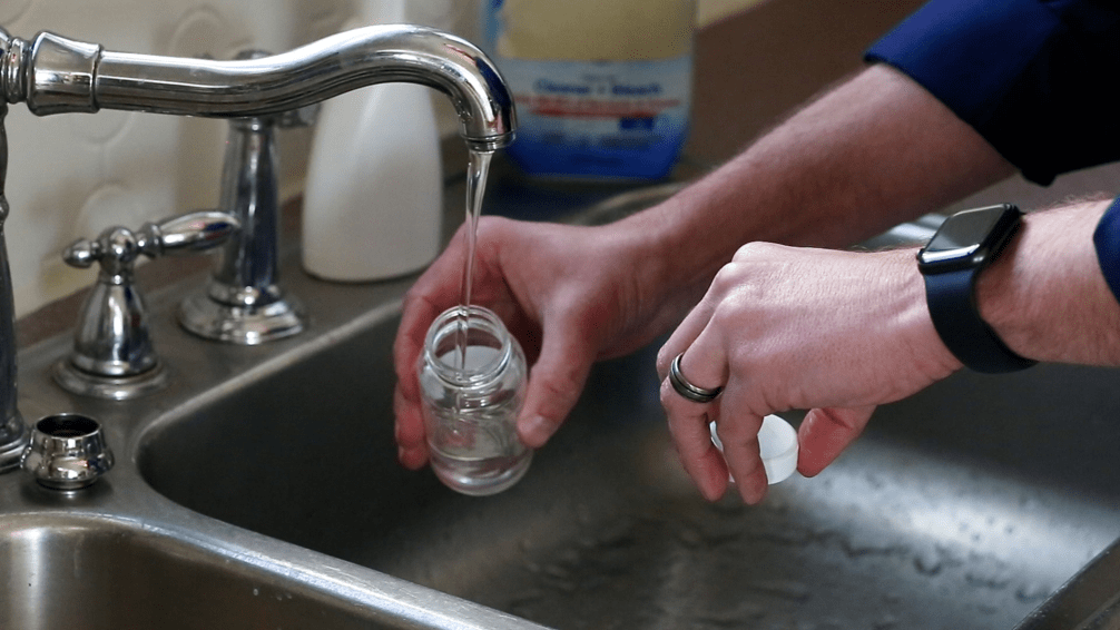 person sampling from their sink