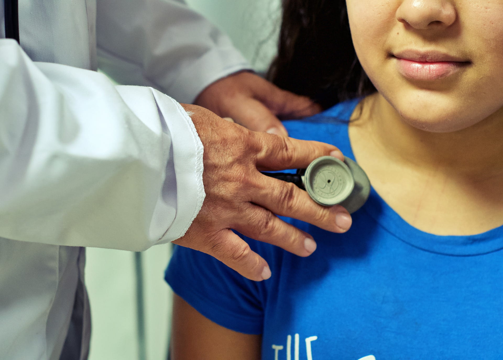 young girl at a check up, doctor has stethoscope on child