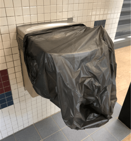 drinking fountain with black bag over it, indicating it is not in use
