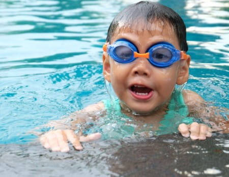 Boy in swimming pool with goggles