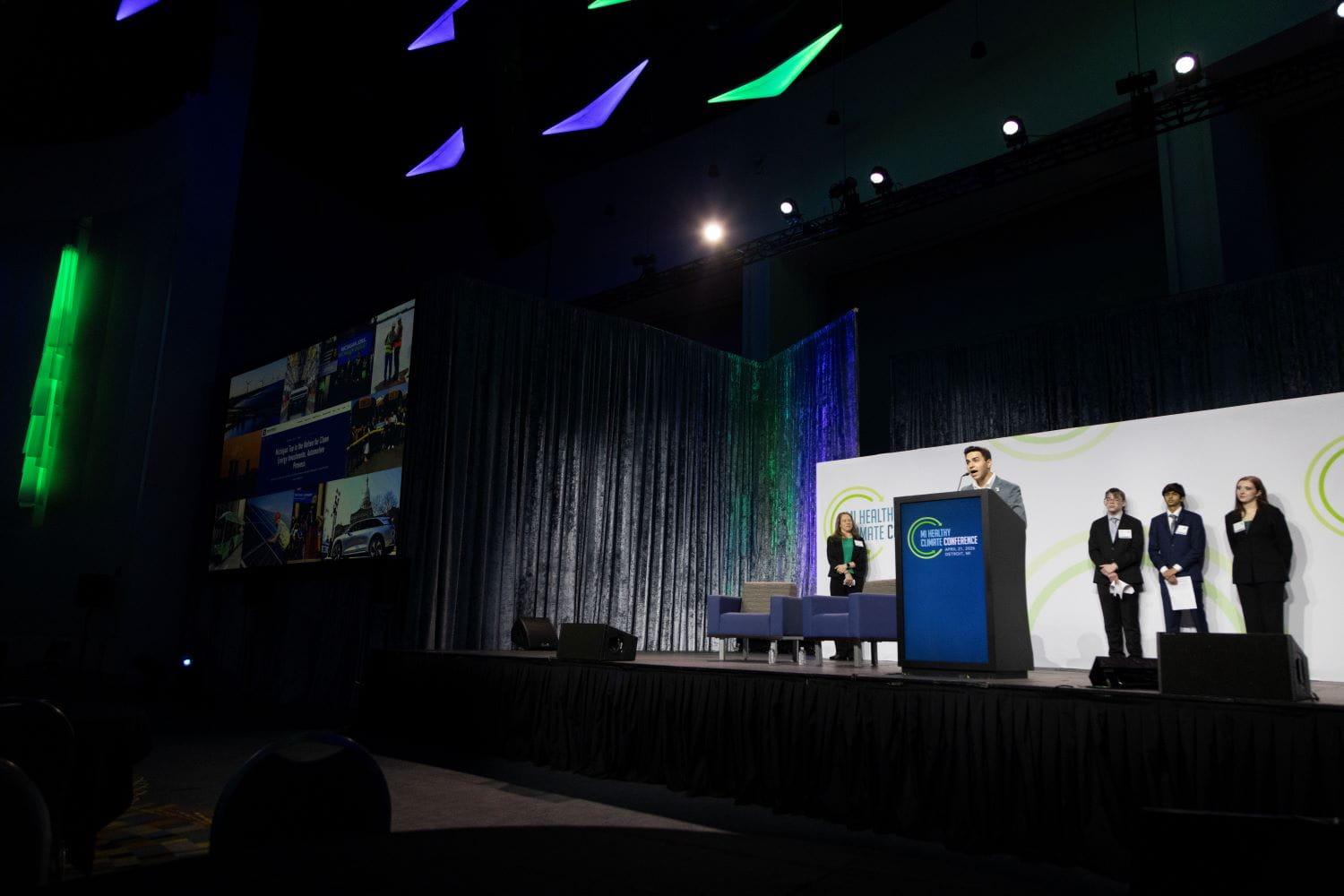 A speaker standing on stage at a podium during the MI Healthy Climate Conference