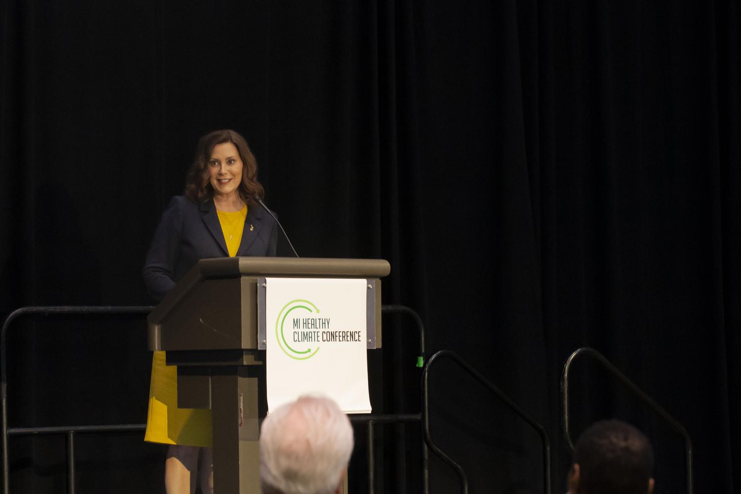 Governor Whitmer stands at a podium speaking to attendees at the MI Healthy Climate Conference