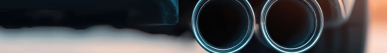 dual exhaust pipes on a sleek vehicle, showcasing automotive design and engineering excellence in sunset light.