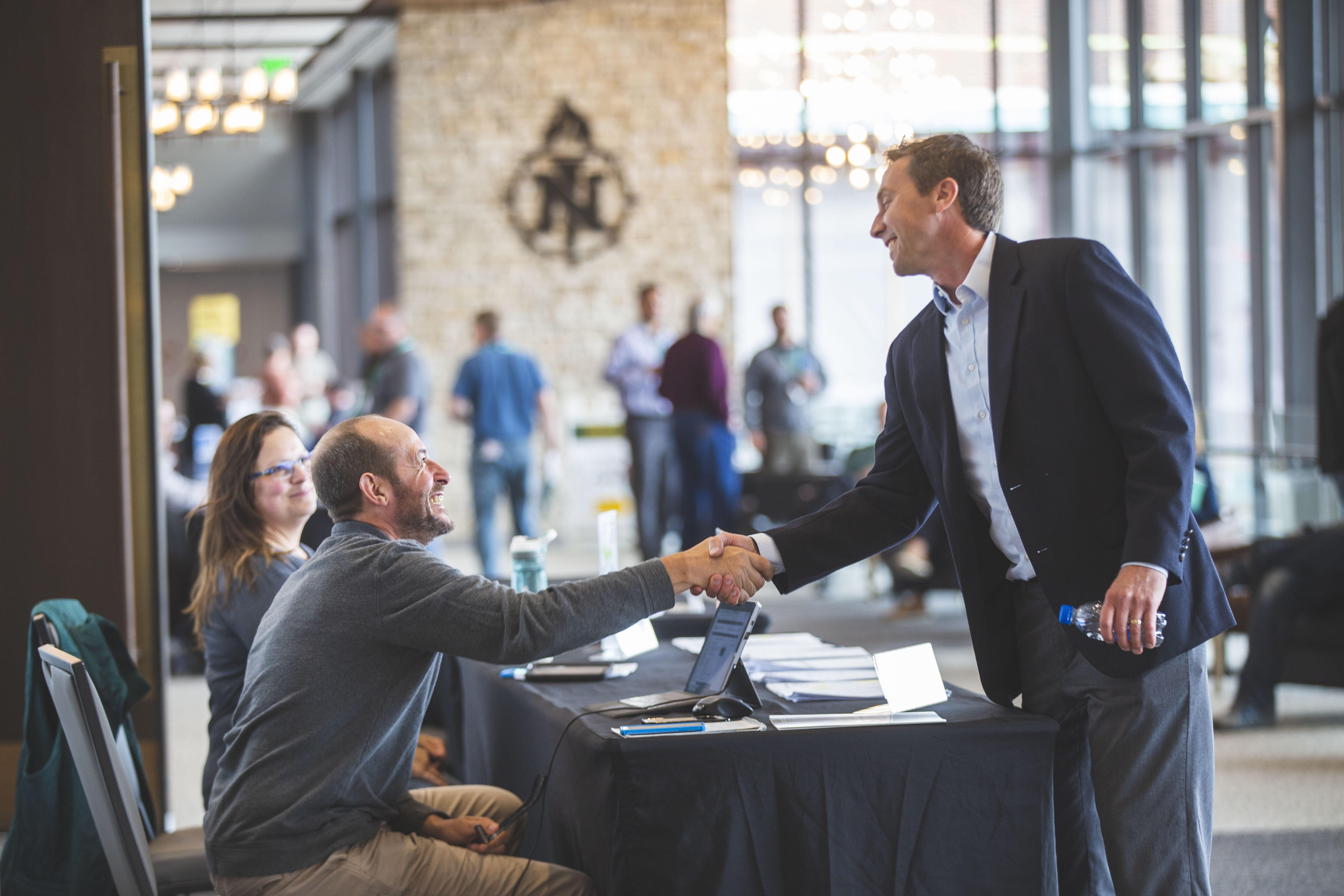 Two men standing over table talking at Michigan Environmental Compliance Conference