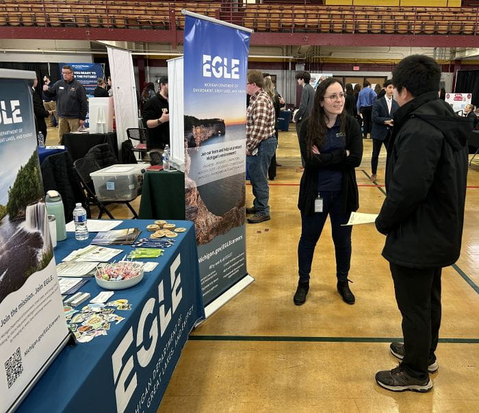 EGLE staffer Tori Starry talks with a student at a career fair at Central Michigan University.