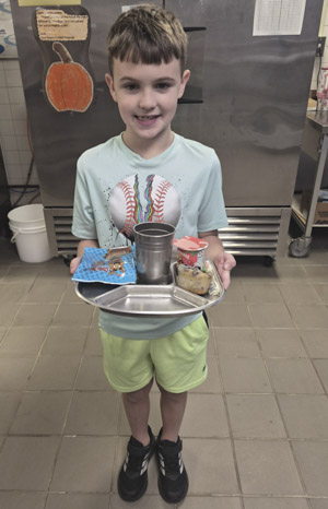 Conner Baxter, a second grader at Central Elementary School in Davison, with a reusable food tray and cup. Credit: We ReUse.