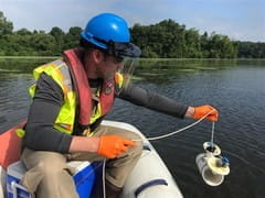 EGLE staff conducting water quality monitoring using a Van Dorn sampler