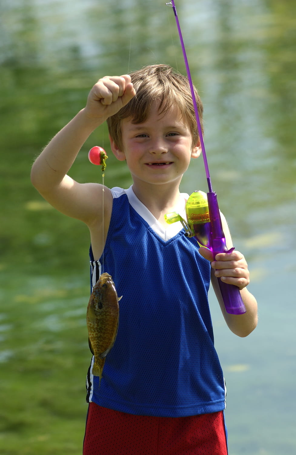 A child displays a fish on a fishing pole caught at the 2005 Kirtland Warbler Festival.
