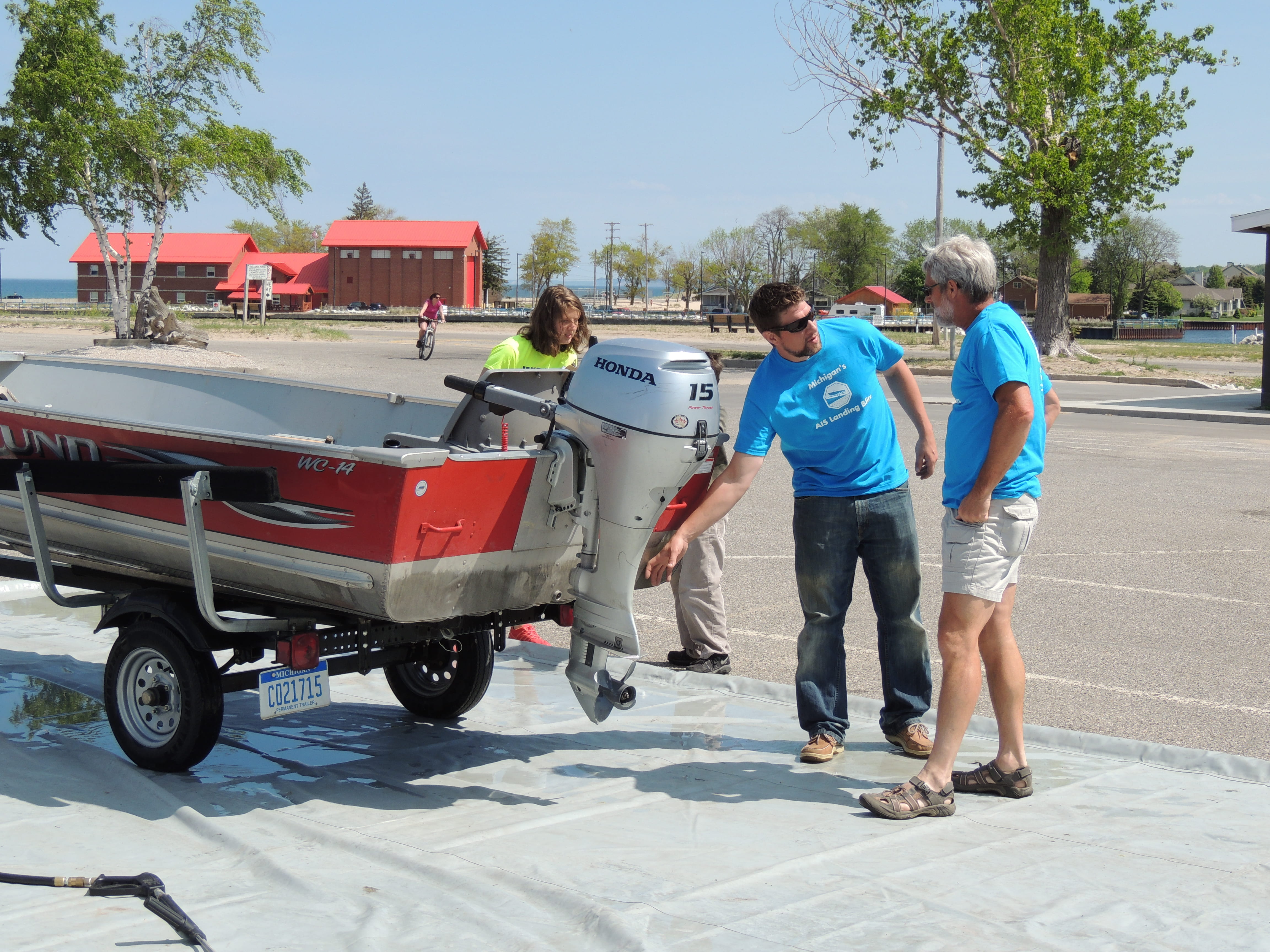 AIS Landing Blitz volunteers demonstrate how to clean, drain and dry a boat to prevent the spread of invasive species