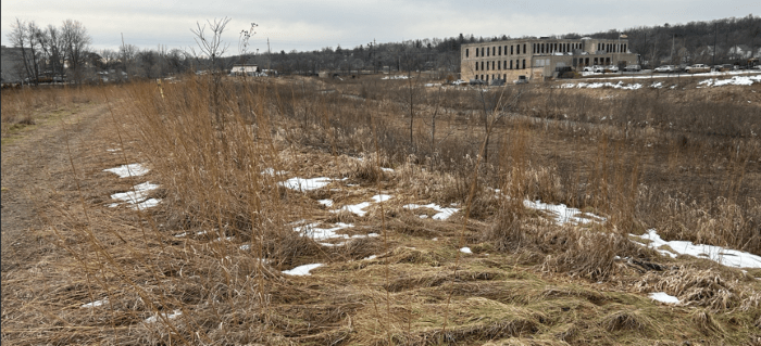 Trail behind site of the future William Schma House in Kalamazoo, showing former paper mill building.