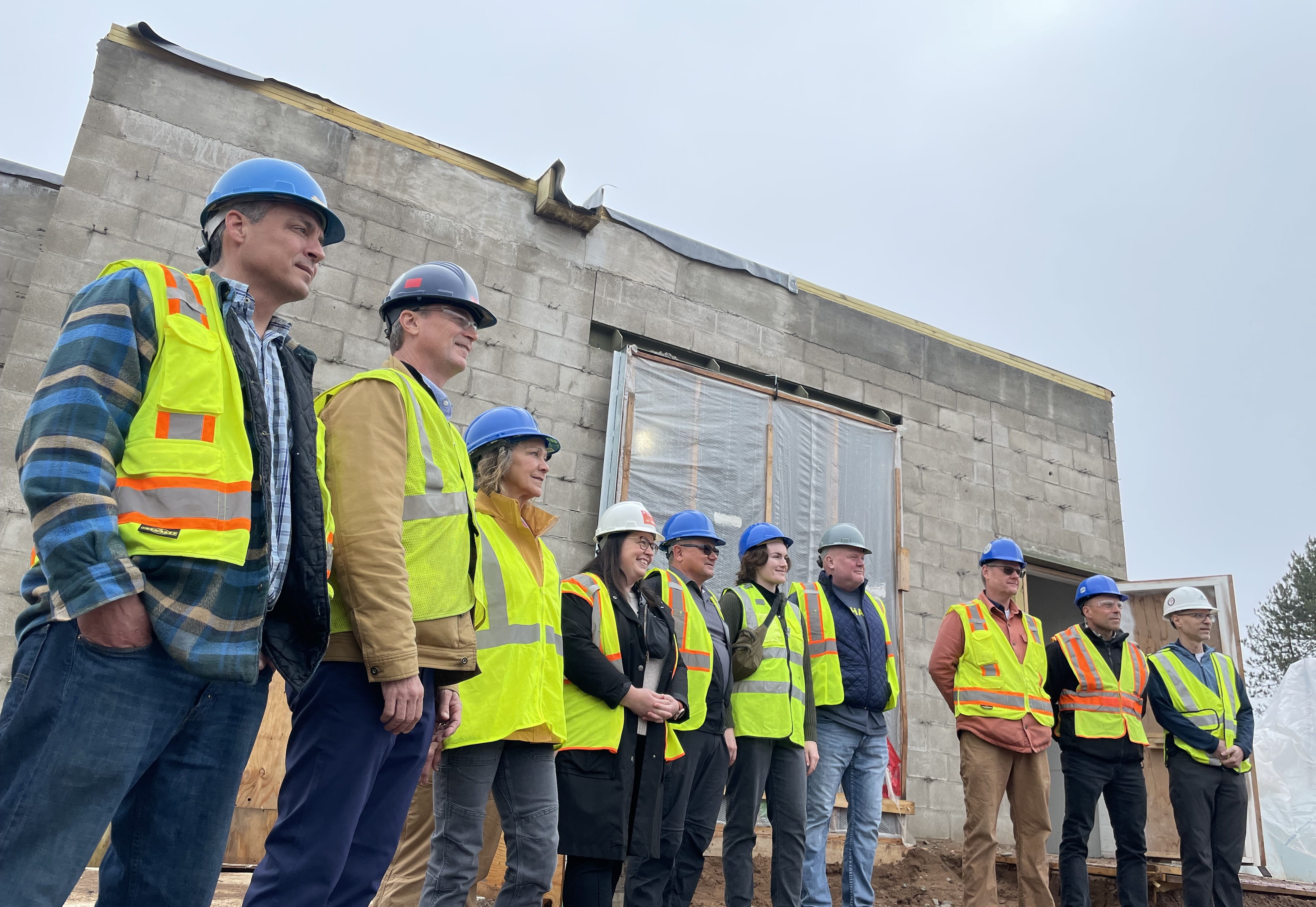 Local officials and Director Roos are all smiles amid construction at the Marquette Area Wastewater Treatment Facility.