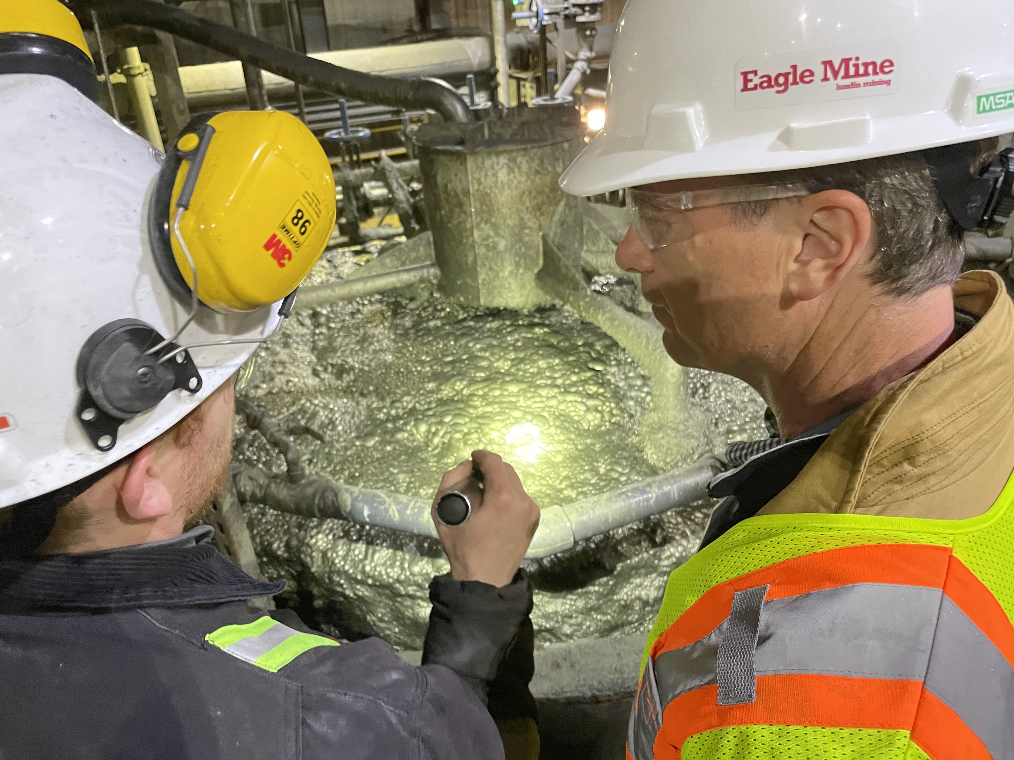 ELGE Director Phil Roos, right, listens as an Eagle Mine representative explains the process of extracting nickel from ore at Humboldt Mill.