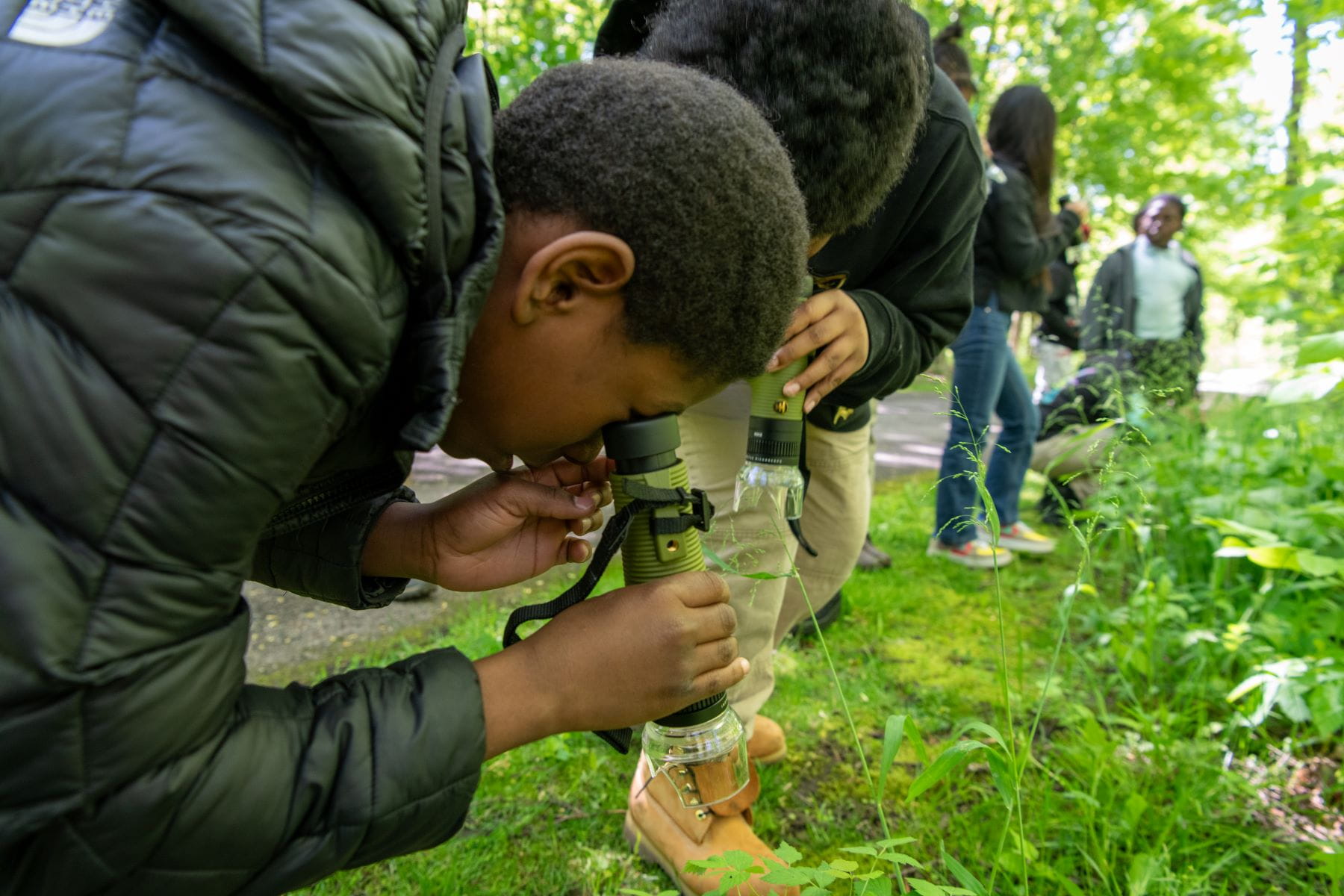 Mackenzie Elementary Middle School students, of Detroit, look for small insects with microscopes.