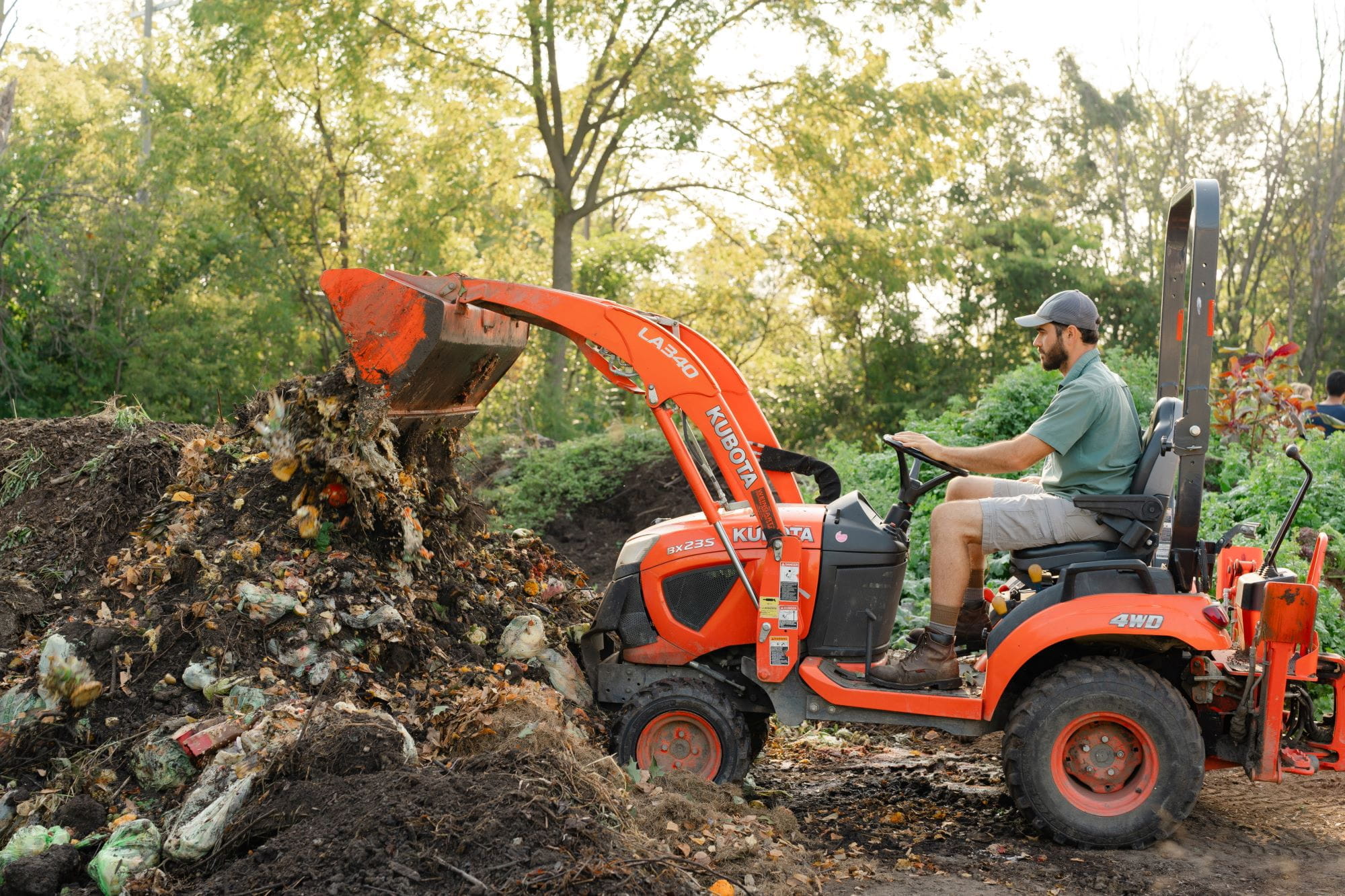 Person on tractor at Sanctuary Farms compost site.