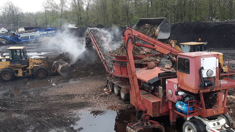Country Oaks' compost operation showing machinery and compost pile.