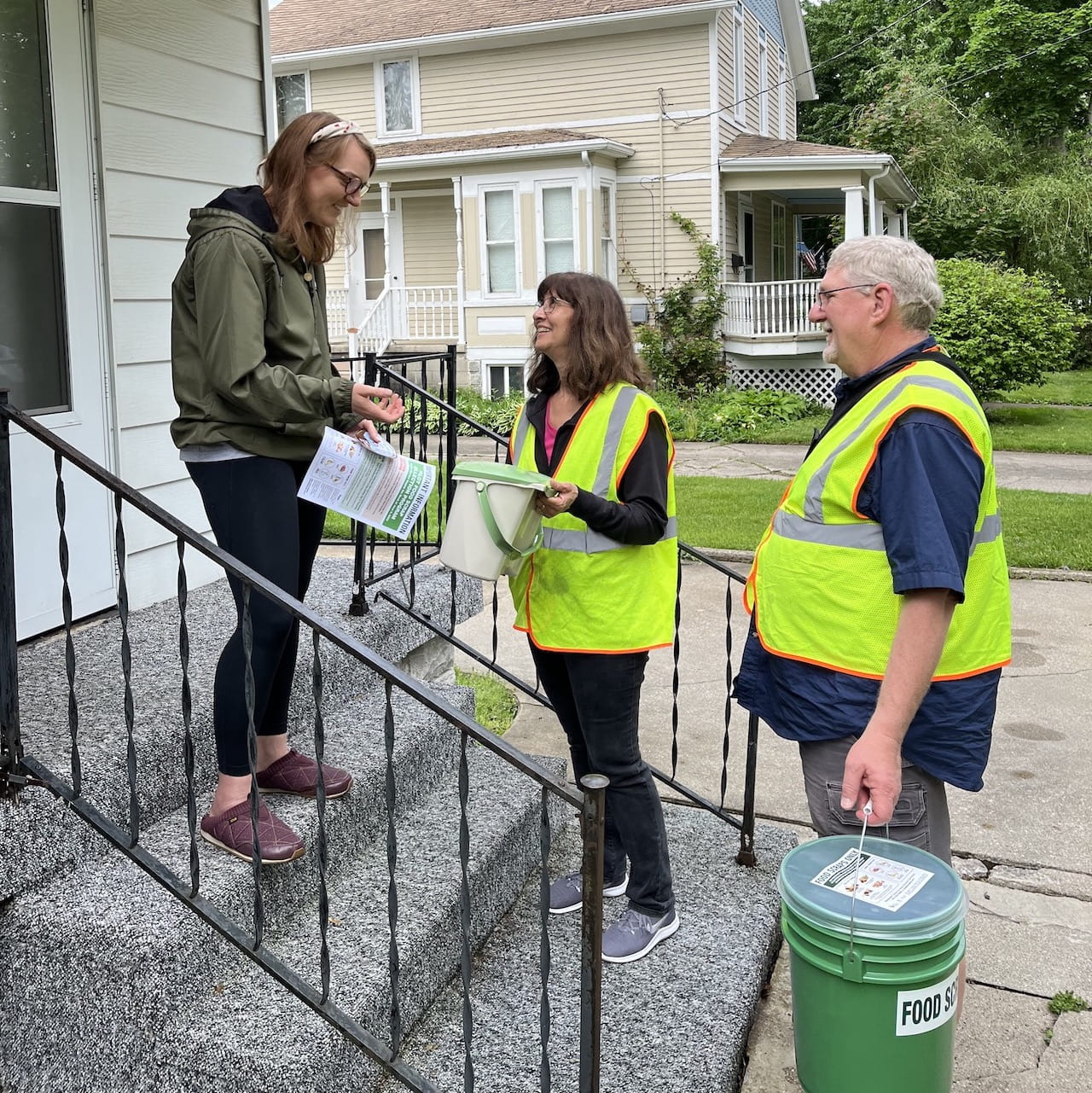 Emily Piper of Bay City, left, discusses details of Iris Waste Diversion Specialists’ new food scrap collection pilot program for residents in Bay City and Saginaw with Iris CEO Sarah Archer and her husband, Darrell Reed.