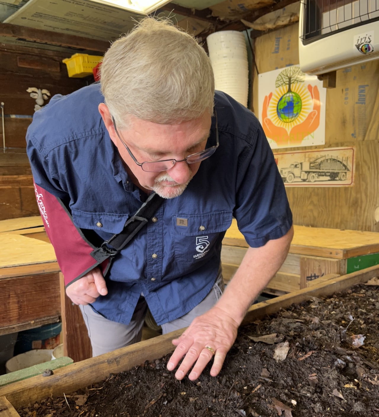 Darrell Reed inspects one of the worm bins used by 5Heart Earthworm Farm that contain castings, essentially worm poop, a nutrient-rich, chemical-free supplement that improves soil health.