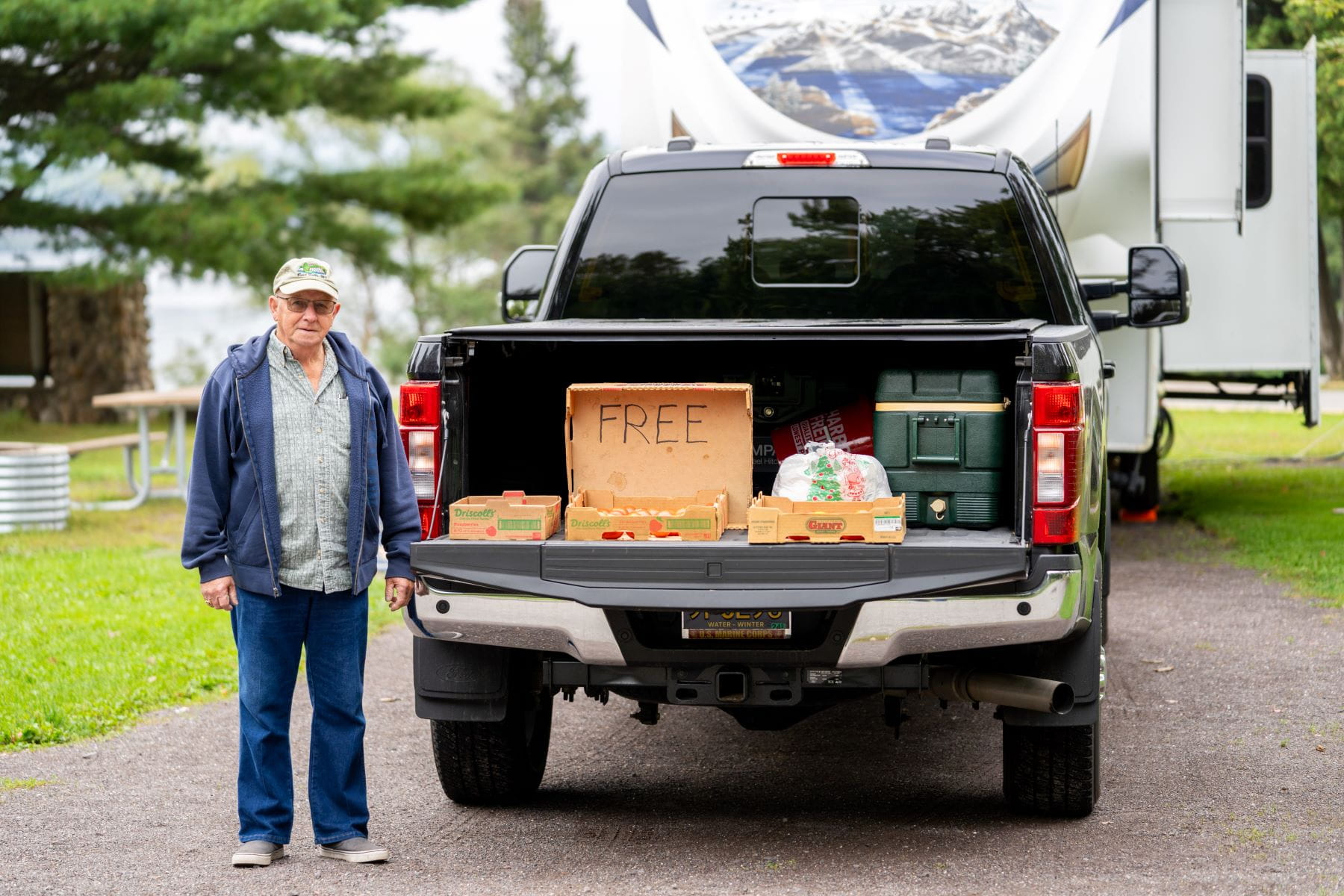 Man next to pickup truck with free tomatoes at Baraga State Park, summer 2023.