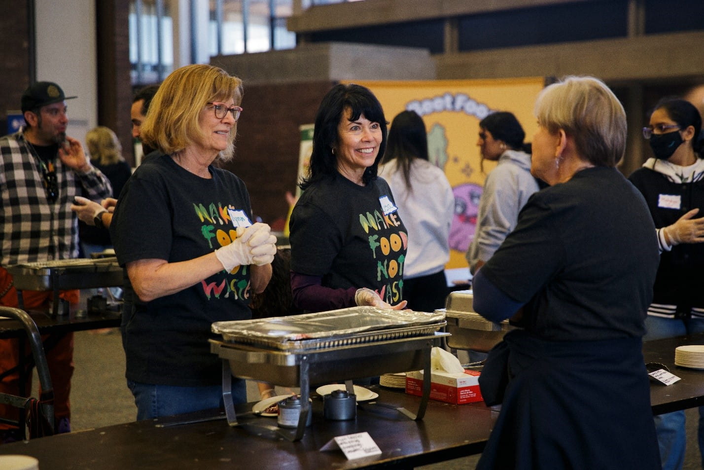 Make Food Not Waste hosted a community feast in Southfield in April 2024 talk with a person. Photo courtesy of Make Food Not Waste.