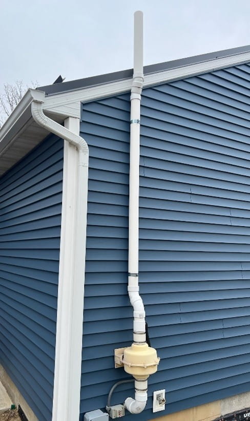 A radon mitigation system located on the exterior of a home.