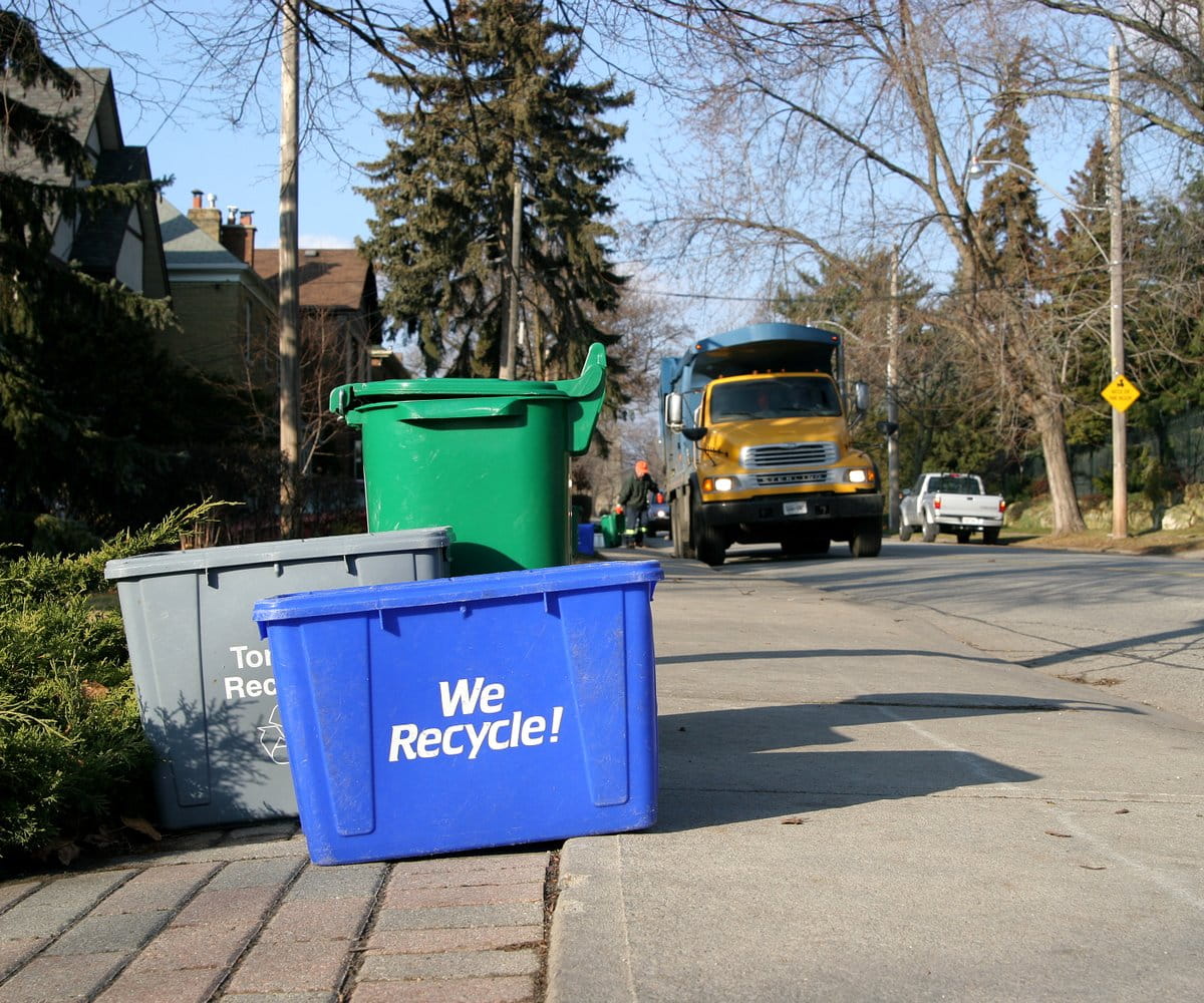 Recycling bins on the curb awaiting pick up. 