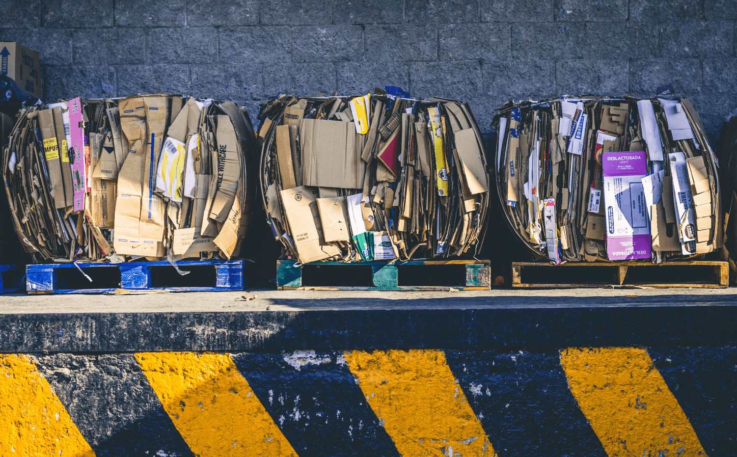 Three large pallets of cardboard, bundled and ready to be recycled