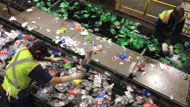 Image of 2 recycling line workers sorting through recyclables