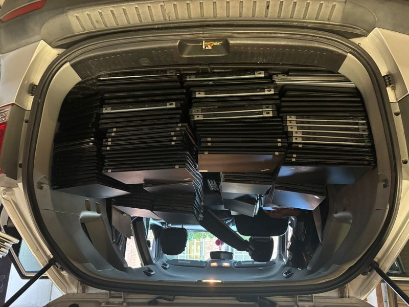 Laptops stacked in the back of a vehicle donated to the Hendricks Foundation by Agios Pharmaceuticals in Cambridge, Mass.