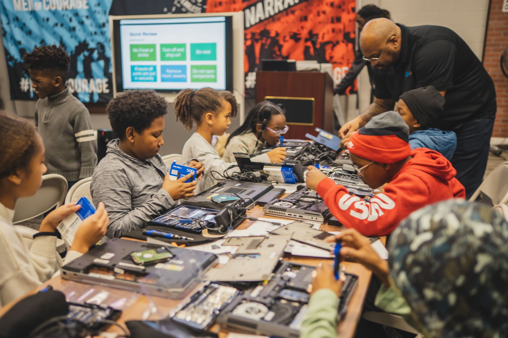 Students at a laptop refurbishment training workshop at the 2024 Hendricks Foundation Tech Camp
