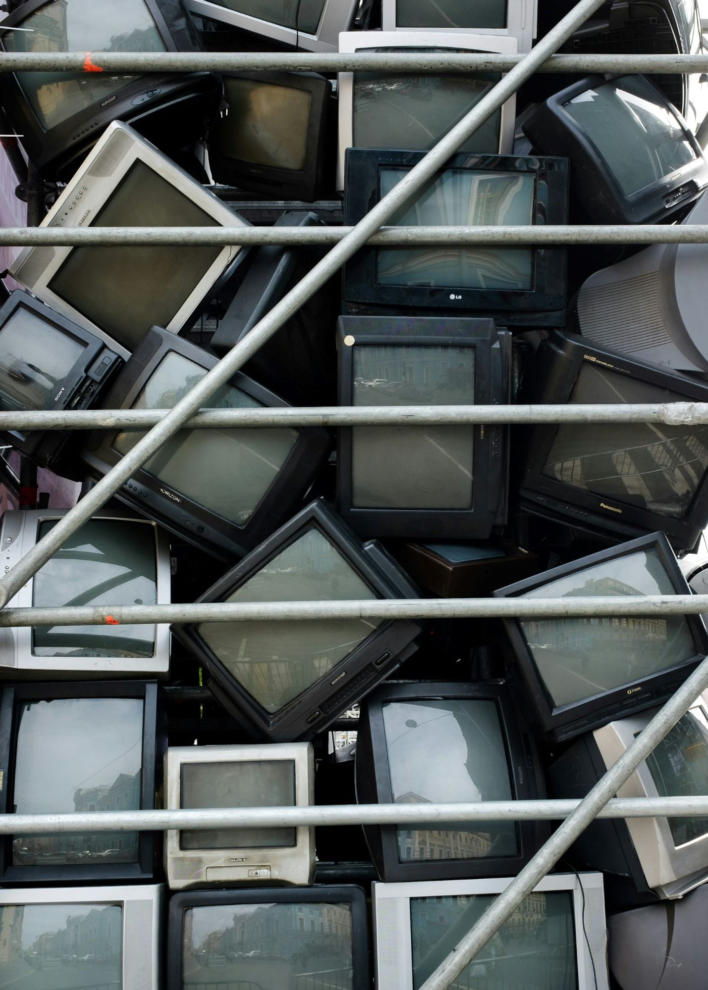a bunch of old televisions stacked to be disposed