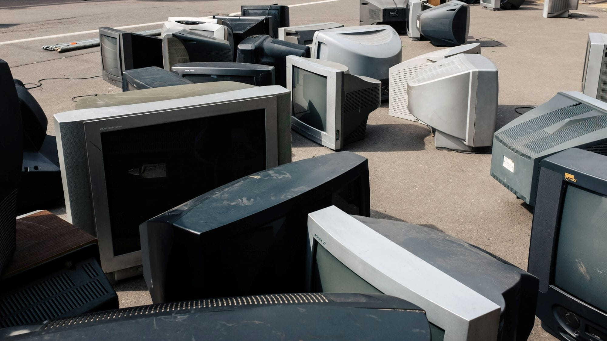 a bunch of old box televisions sitting in a parking lots to be disposed