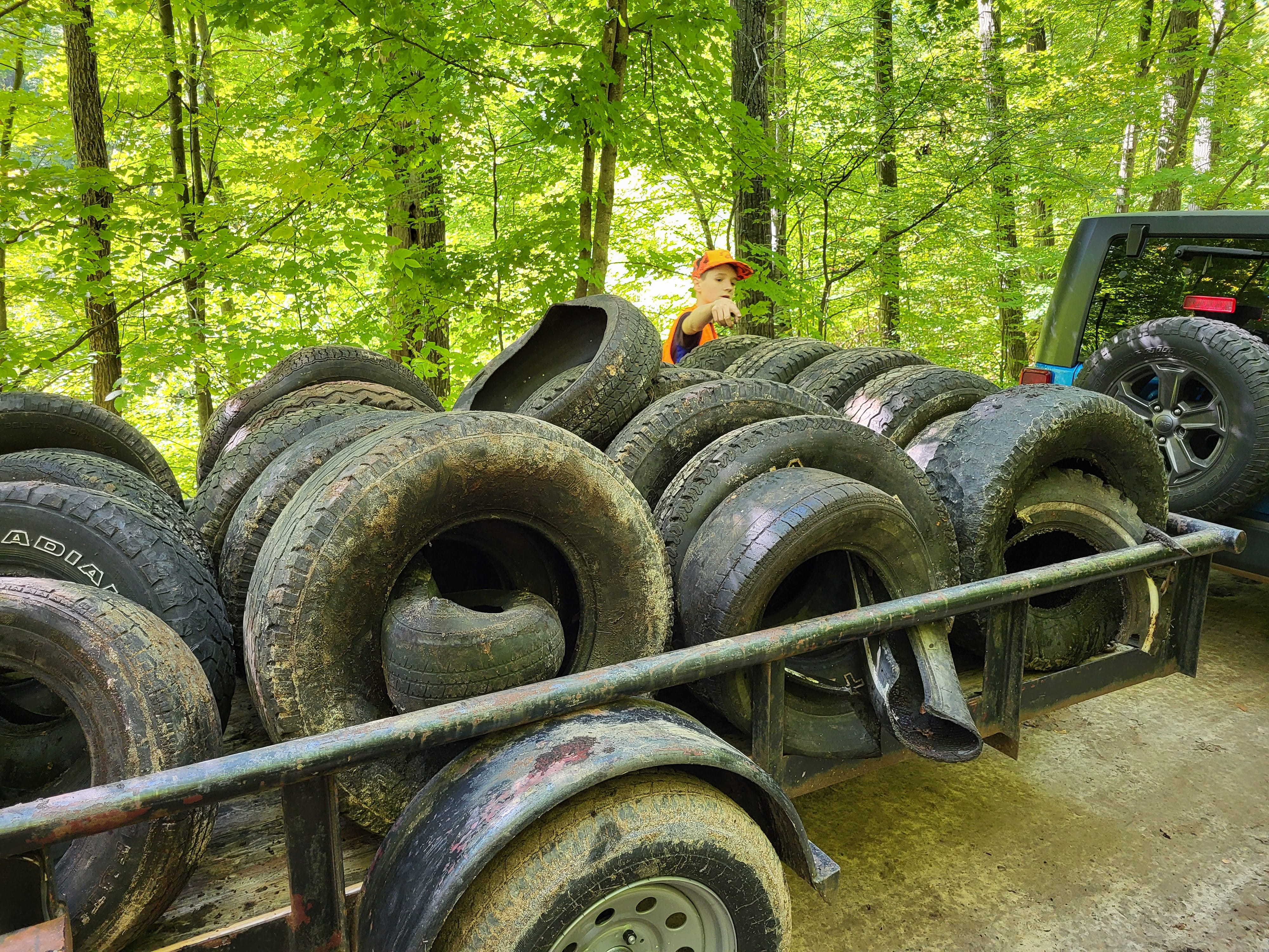 Cole Sherman, Eagle Scout, loads scrap tires onto trailer. Courtesy of DNR.