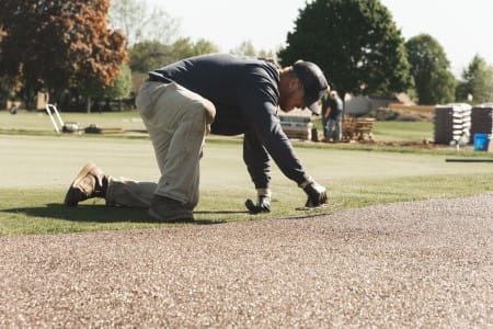 A worker installs a Porous Pave pathway at Spring Meadows Country Club in Linden, Michigan. Photo courtesy of Porous Pave.