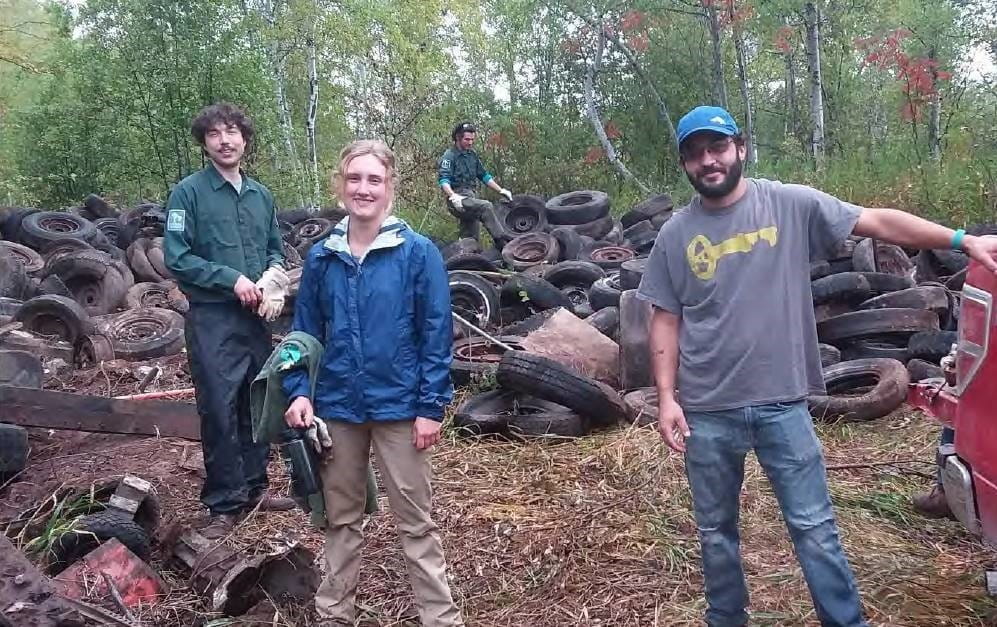 Four people at Superior Watershed Partnership scrap tire clean up project.