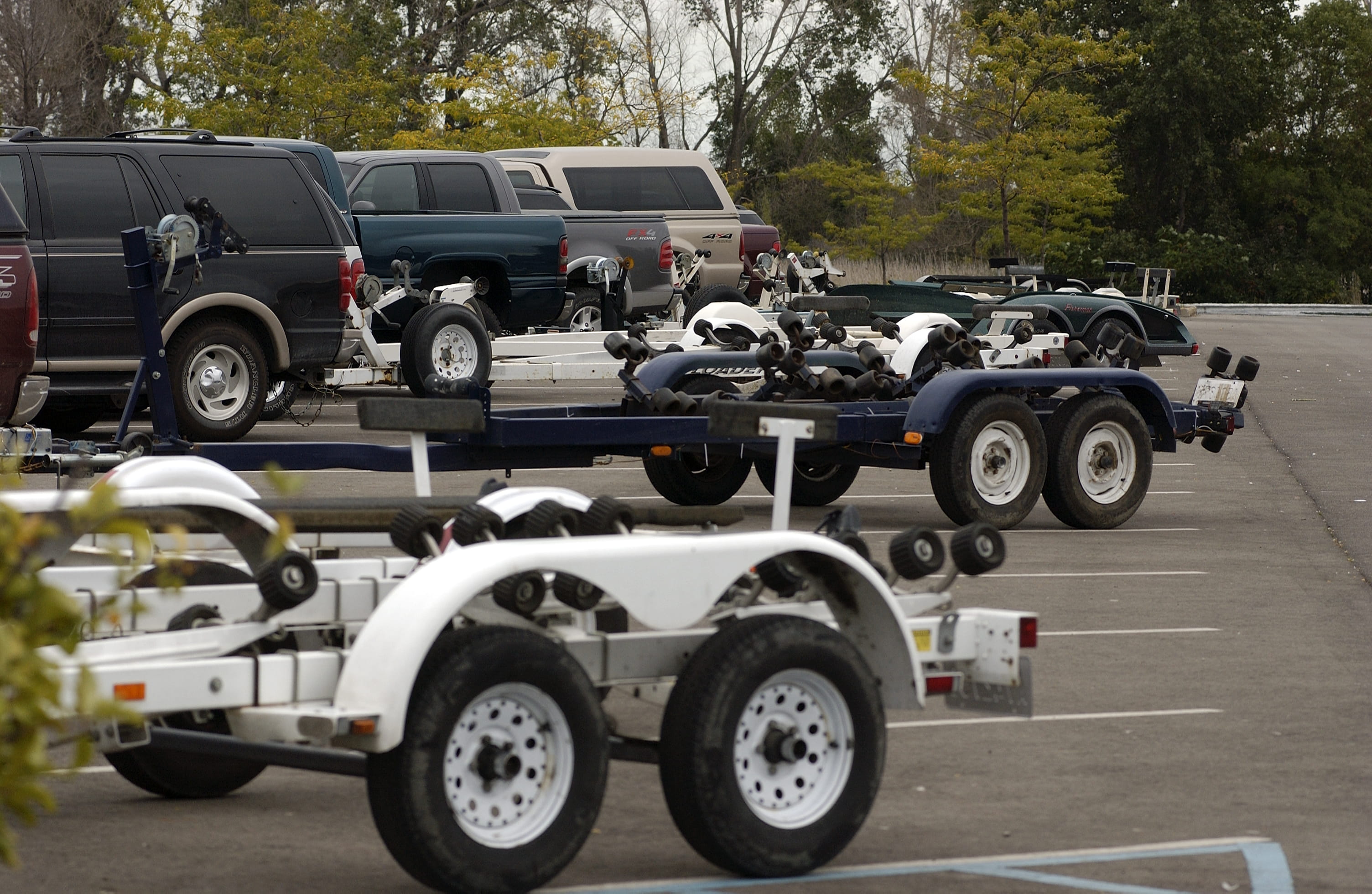 Boat trailers in a parking lot showing their tires.