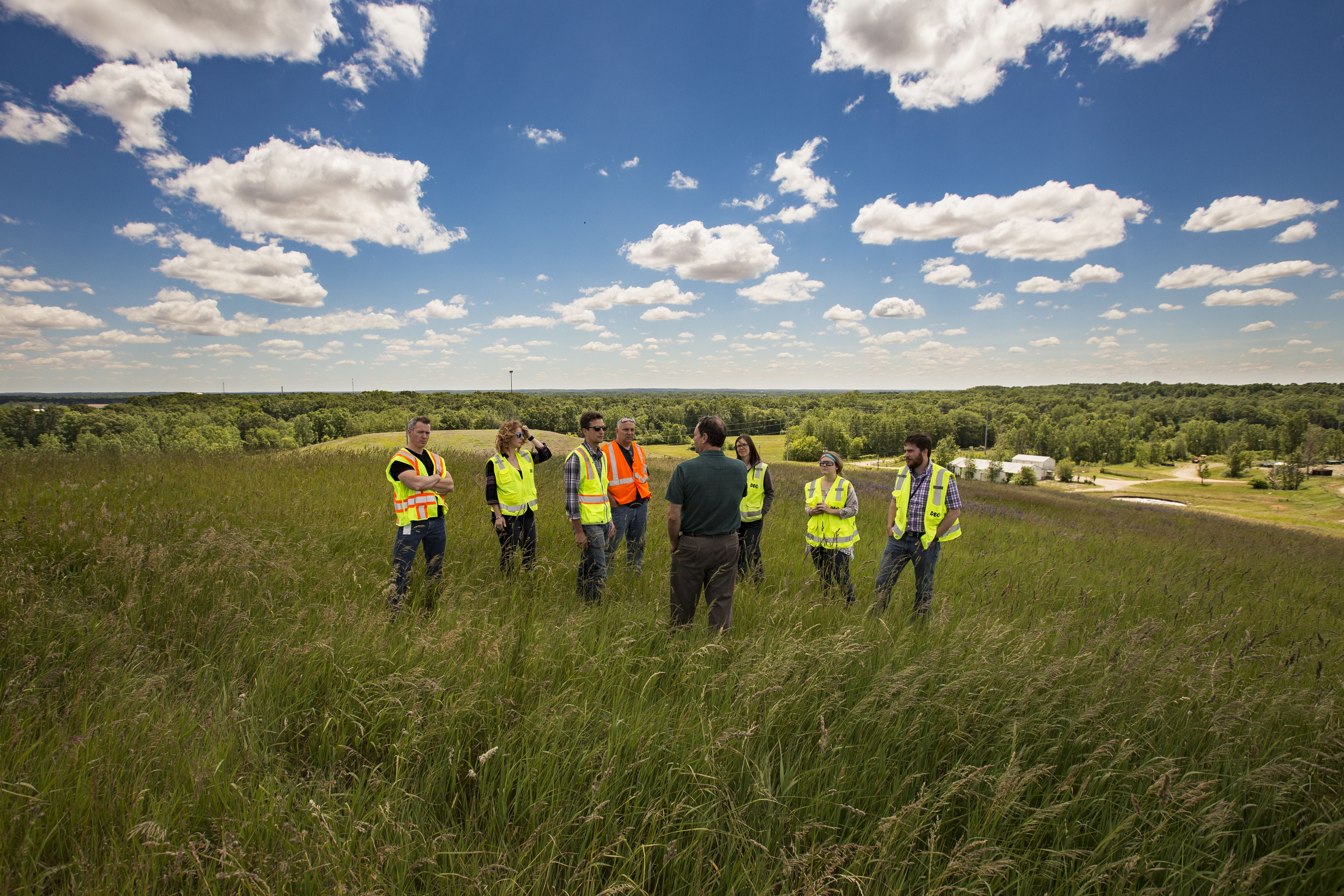EGLE staff learning about and standing on a closed landfill.