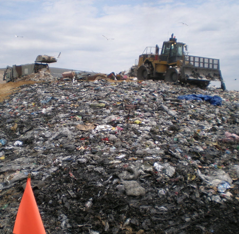 Heavy equipment spreading trash on a landfill