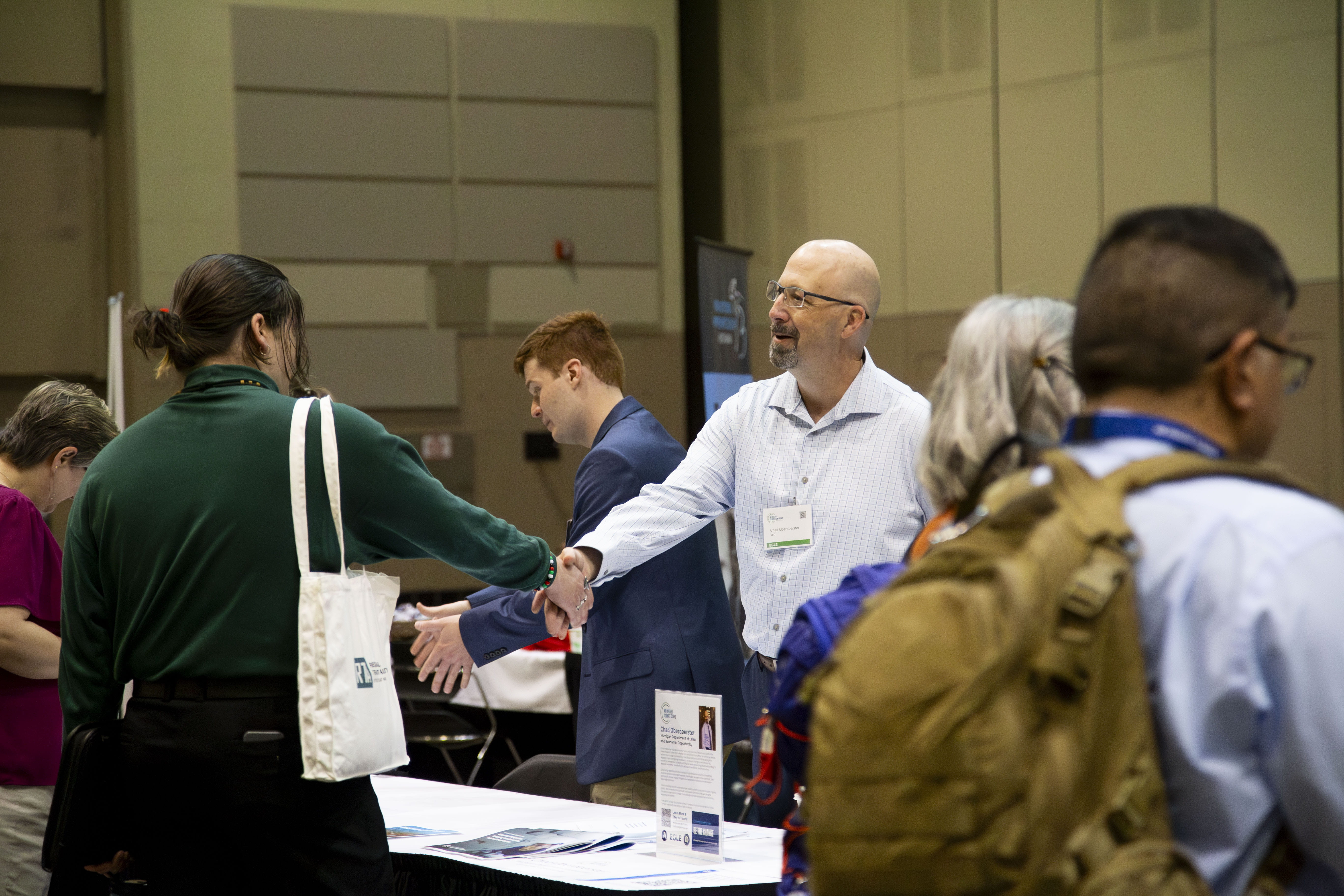 Members of the MI Healthy Climate Corps mingle with conference attendees at exhibitor tables.