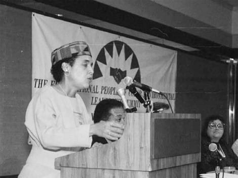 A woman at a podium during the First People of Color Environmental Leadership Summit speaking to a crowd