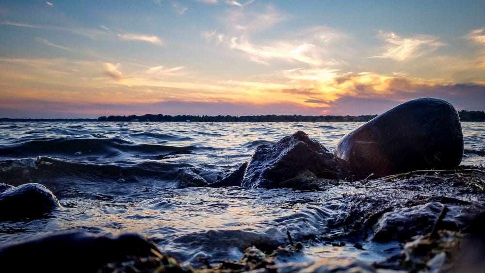 an orange sunset over the dark waters of lake michigan