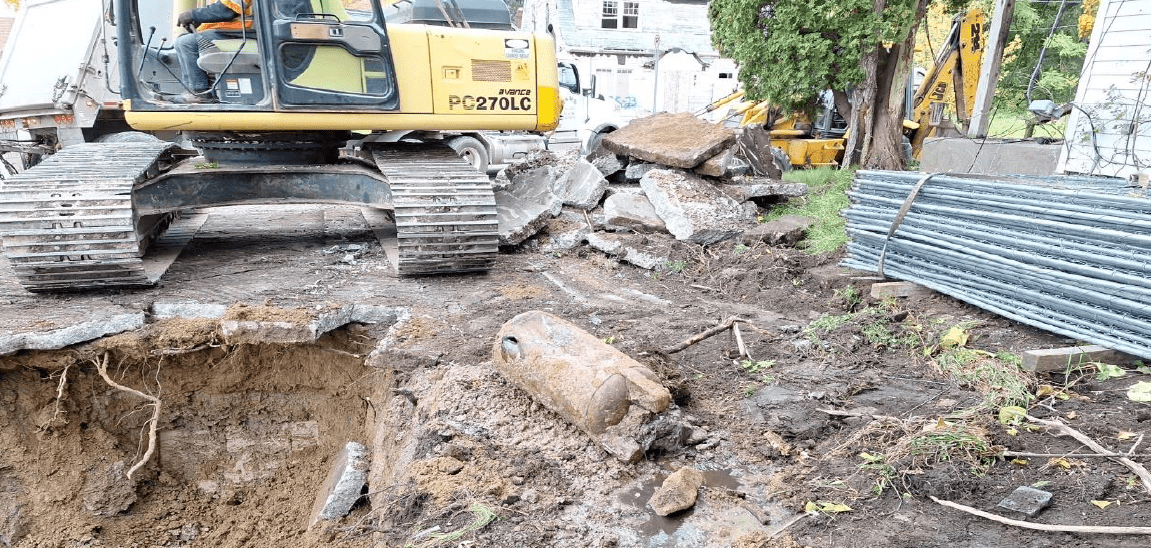 A hydraulic fuel tank in Flint sits next to an excavator and the hole it was removed from.