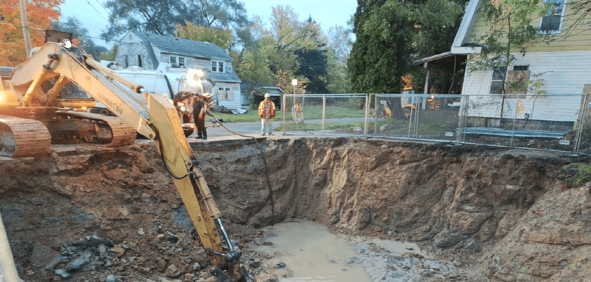 An excavator removes contaminated soil from a former gas station site in Flint.