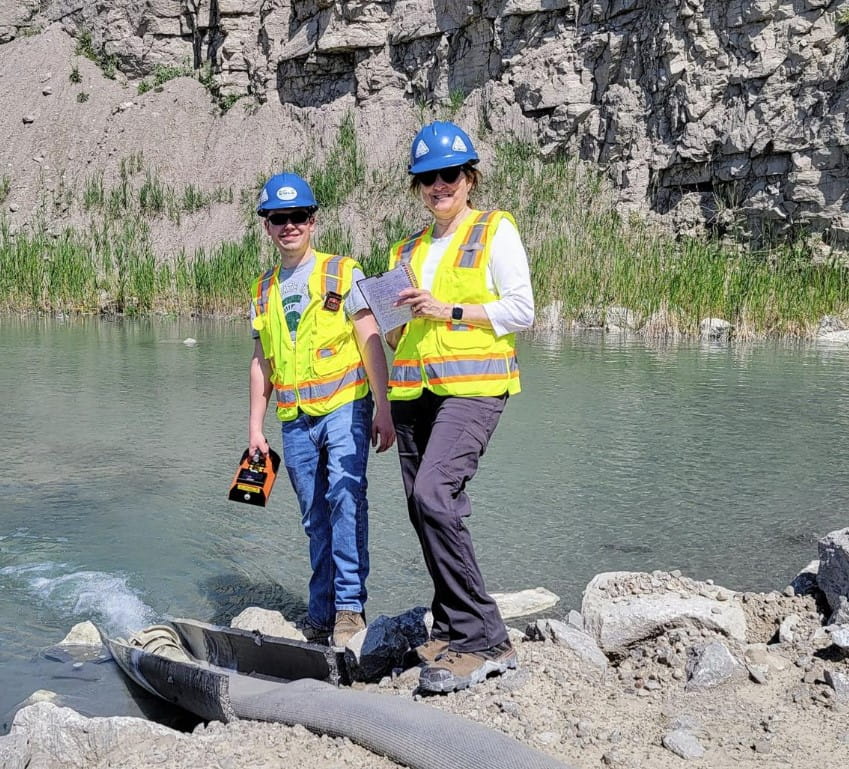 Two air quality staff take gas measurements at a quarry