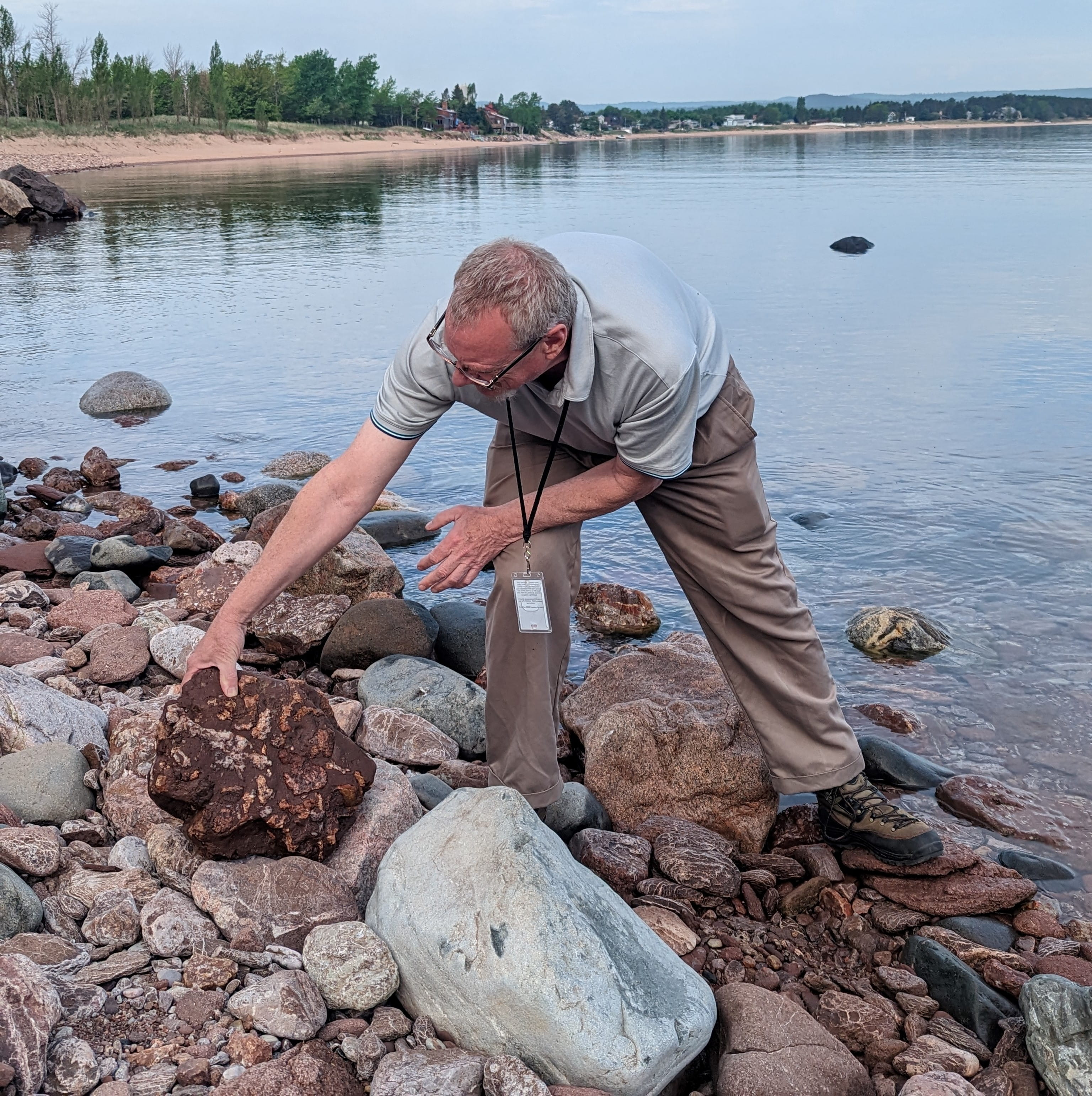 Rob Wolfe, of EGLE's Marquette District Office, examines a sedimentary rock along Lake Superior.