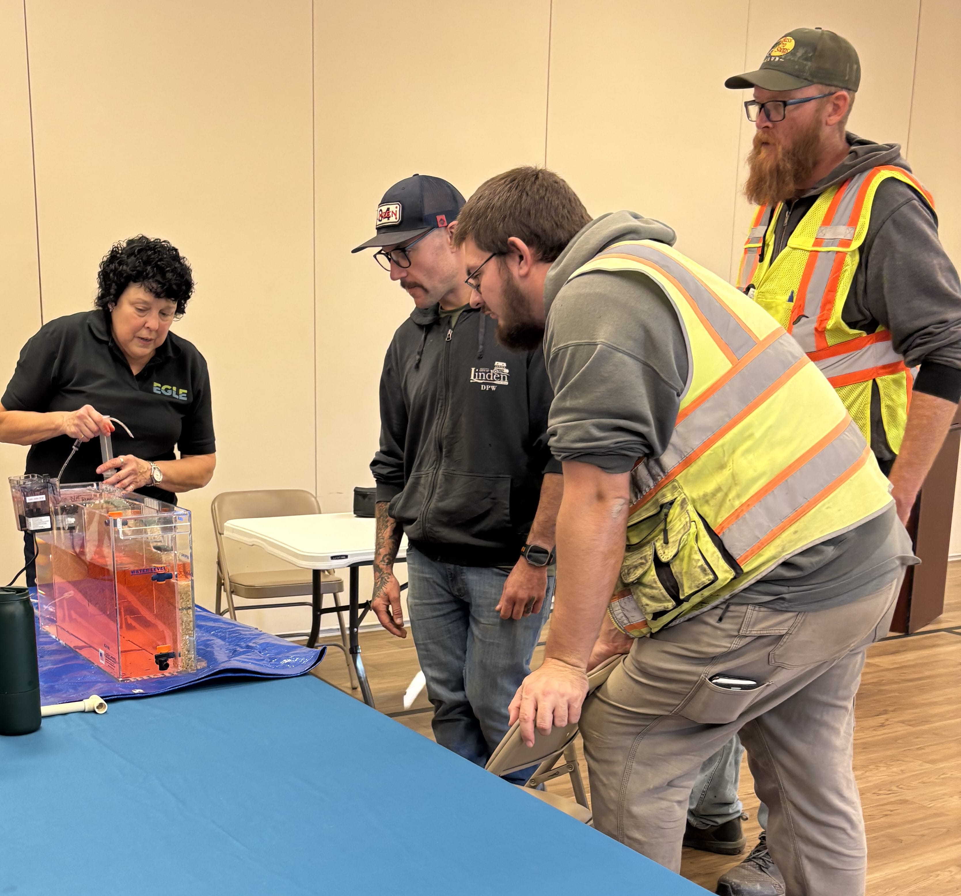 Using a model, EGLE staffer Pam Howd shows City of Linden employees how radon can migrate through the soil and groundwater to get into structures.