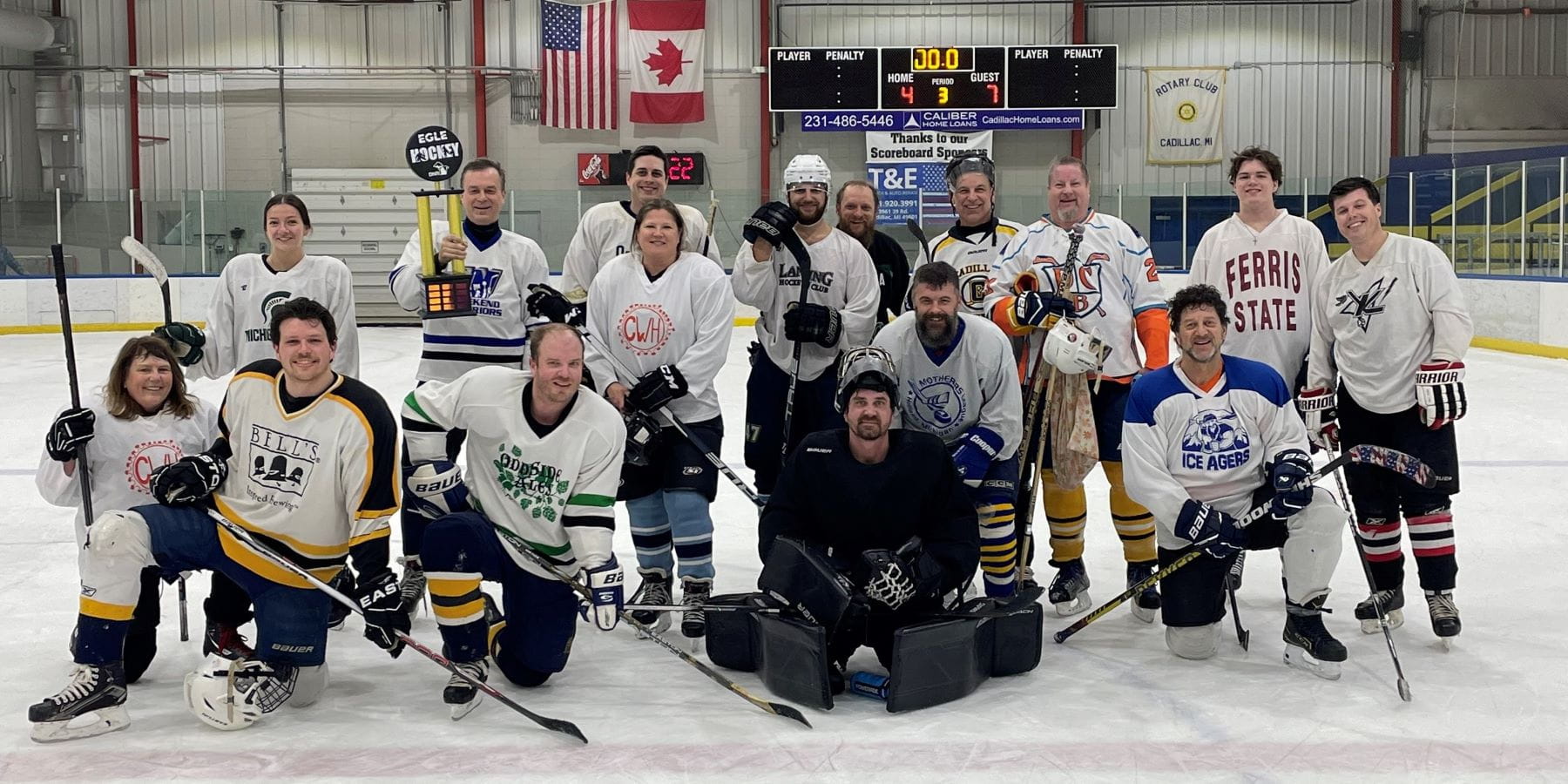 EGLE Director Phil Roos holds the trophy with Team EGLE hockey players.