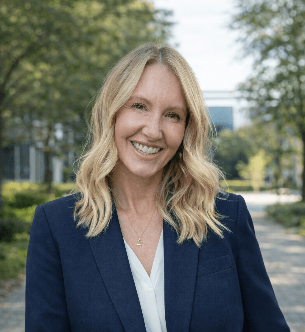 Deputy Director Ann Larson smiling while wearing a white shirt and black suit jacket
