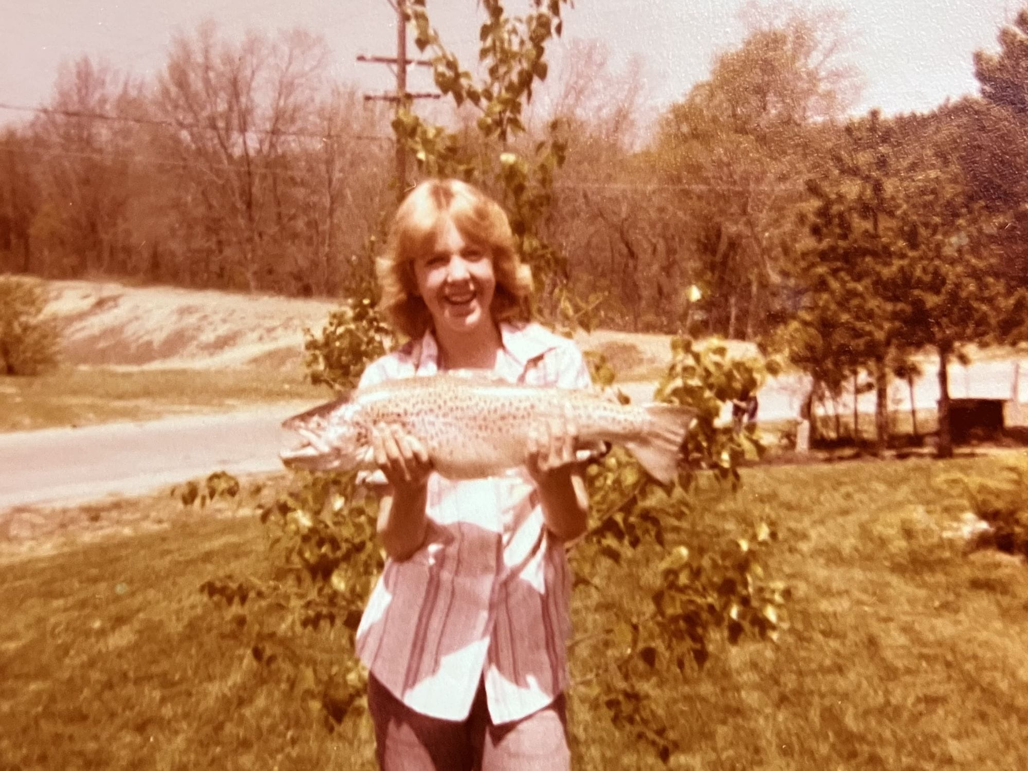 EGLE staffer Regina Young as a child holding an 8-pound brown trout.