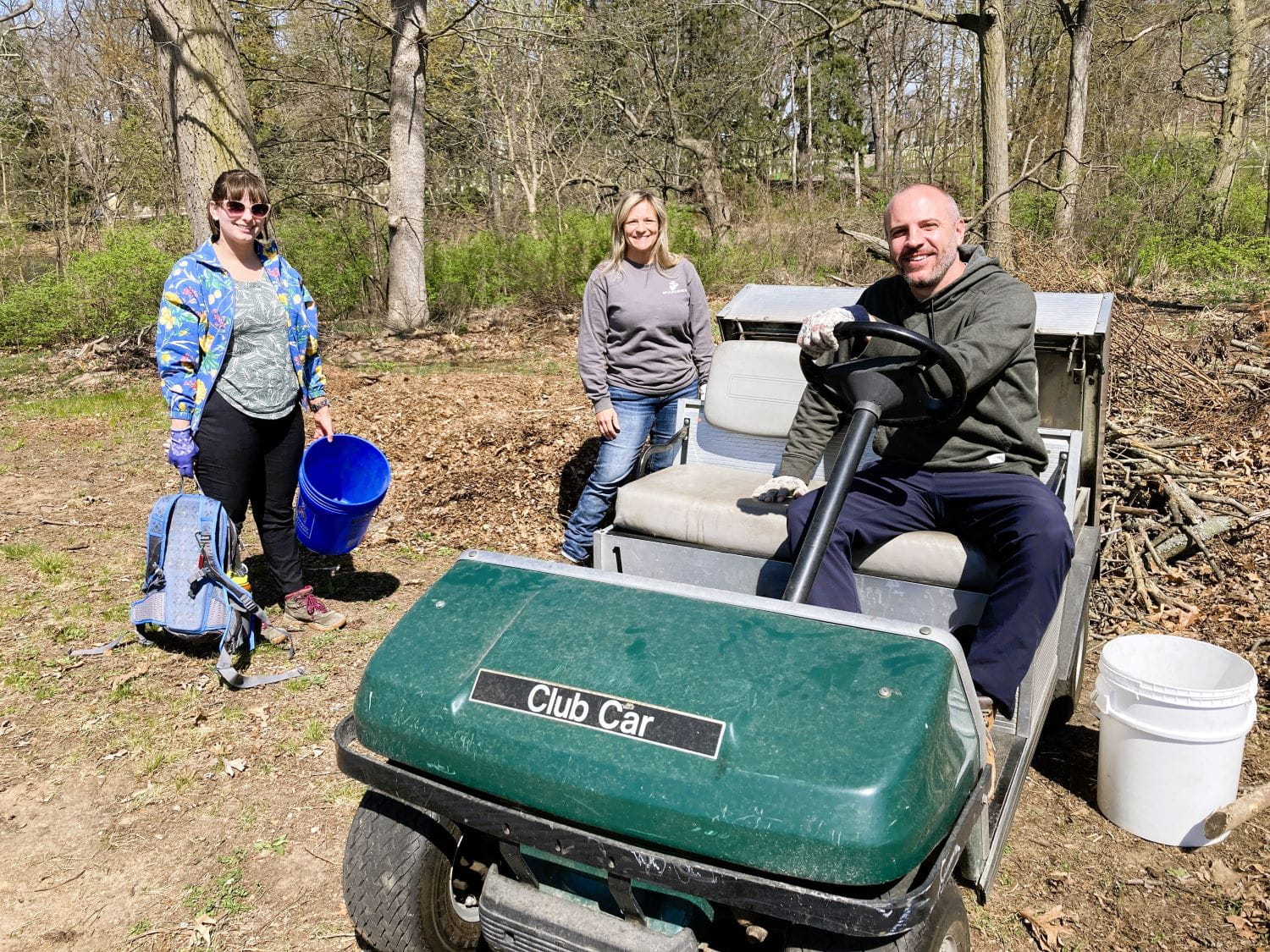 Brittney Beavers, Autumn Henney and Barney Boyer, all of EGLE, take care of debris at the veterans' cemetery in Grand Rapids.